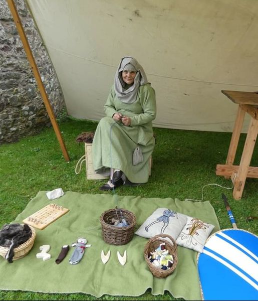 A re-enactor makes clothing