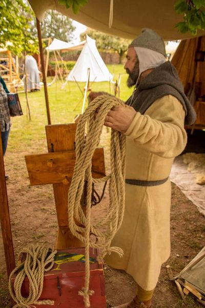 A re-enactor makes rope